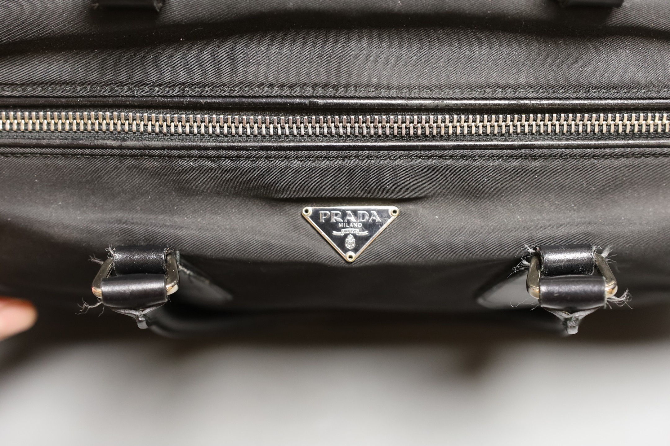 A Prada bowling bag style with zip up compartment